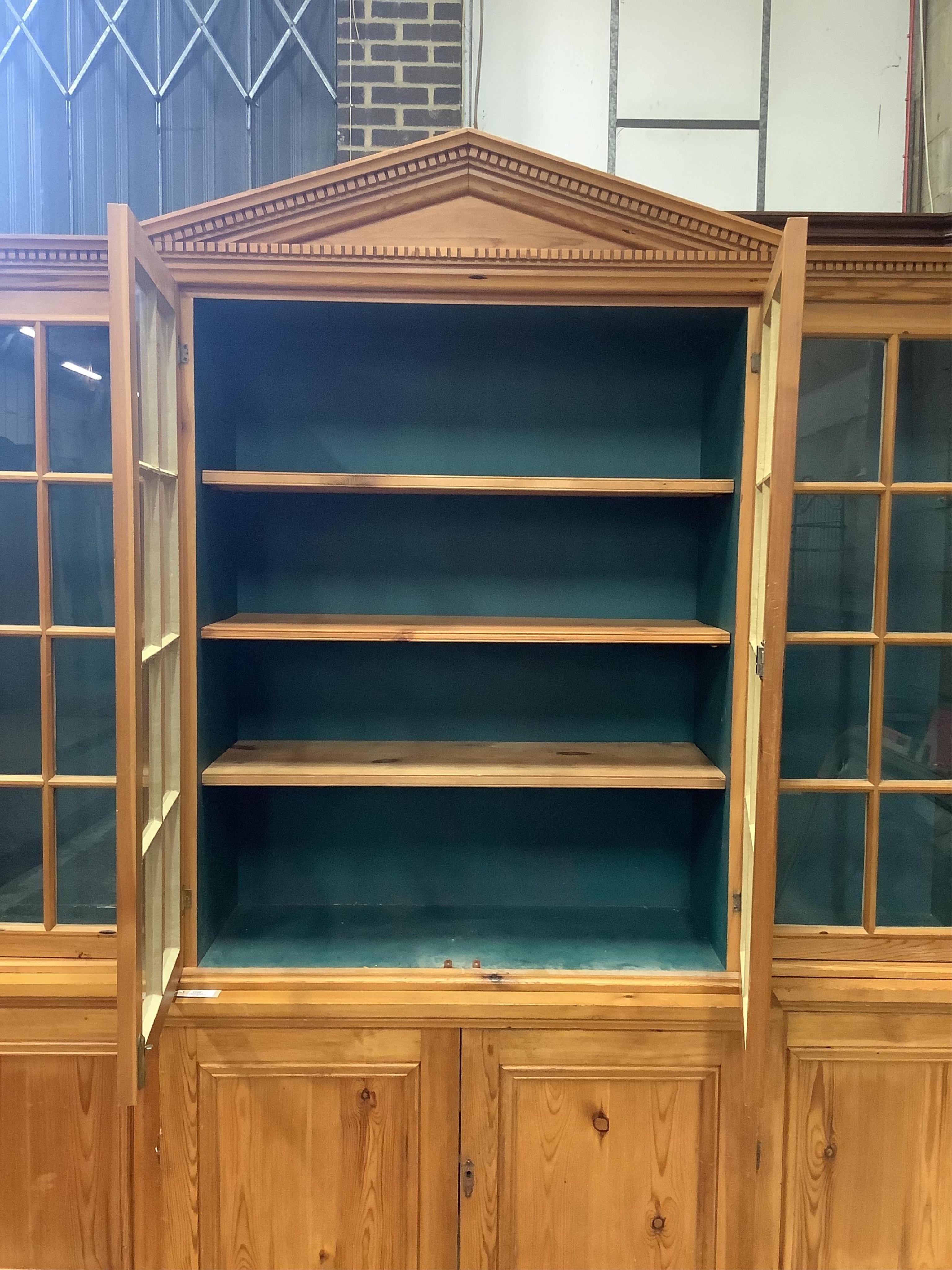 A modern pine breakfront bookcase, width 194cm, depth 44cm, height 207cm. Condition - fair to good